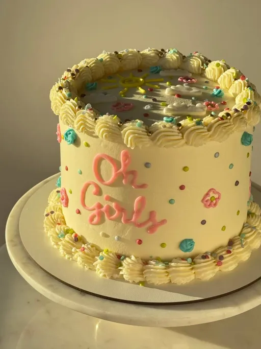 Gâteau rétro jaune pâle avec inscription Oh Girls et vermicelles